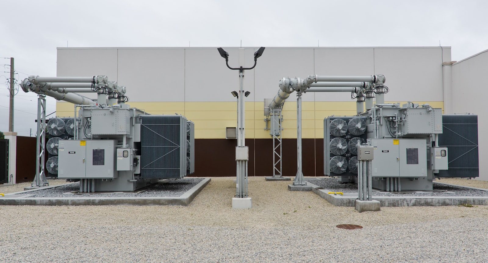 Pair of padmount power transformers outside an industrial facility